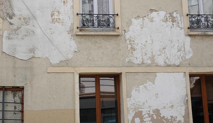 Painting a severely damaged building exterior. Painting a severely damaged building exterior